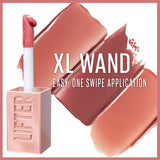 Maybelline Lifter Gloss with a pale pink tube, fuzzy XL wand applicator and glossy nude-pink swatches